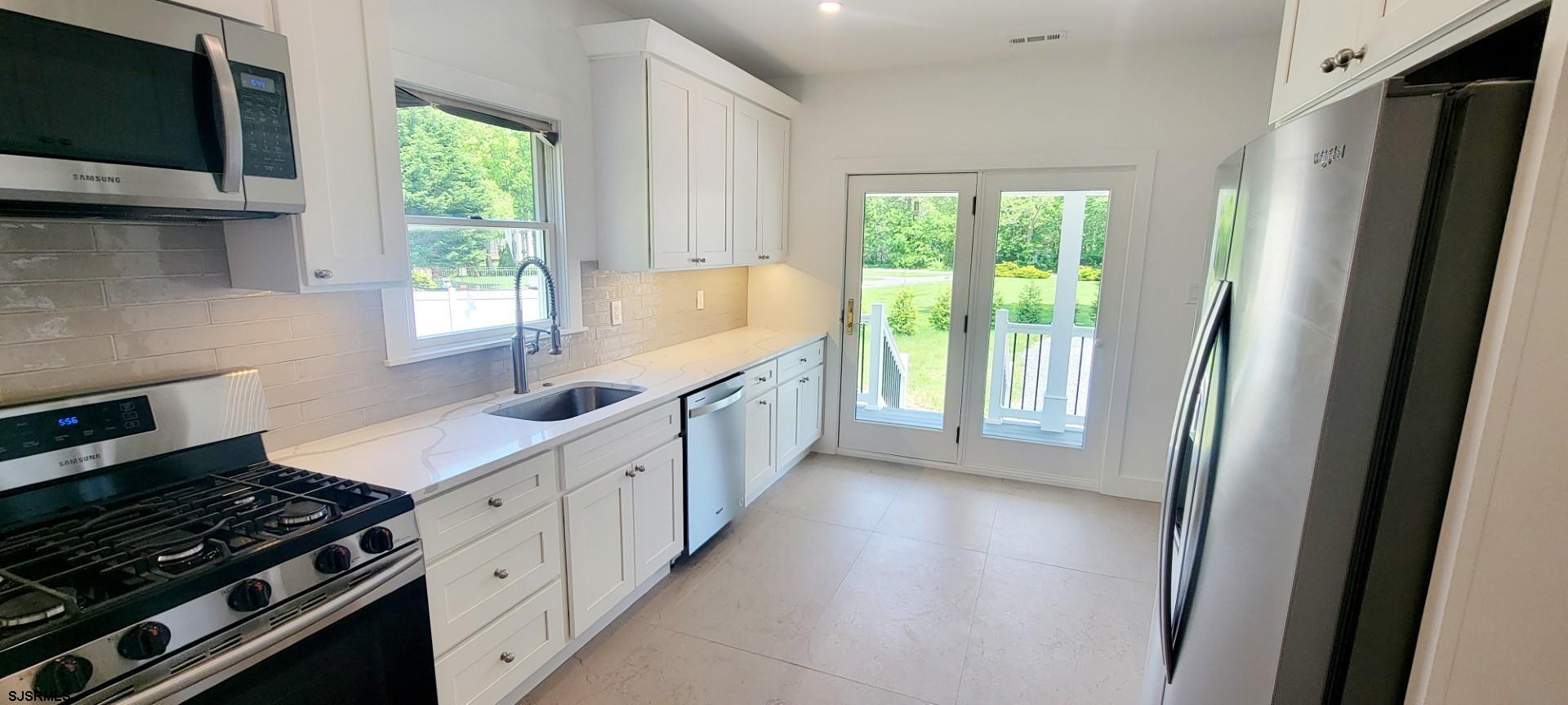 6594 Mill Road Egg Harbor Township, NJ 08234 - Photo 13 of 72 a kitchen with granite countertop a sink stove and refrigerator
