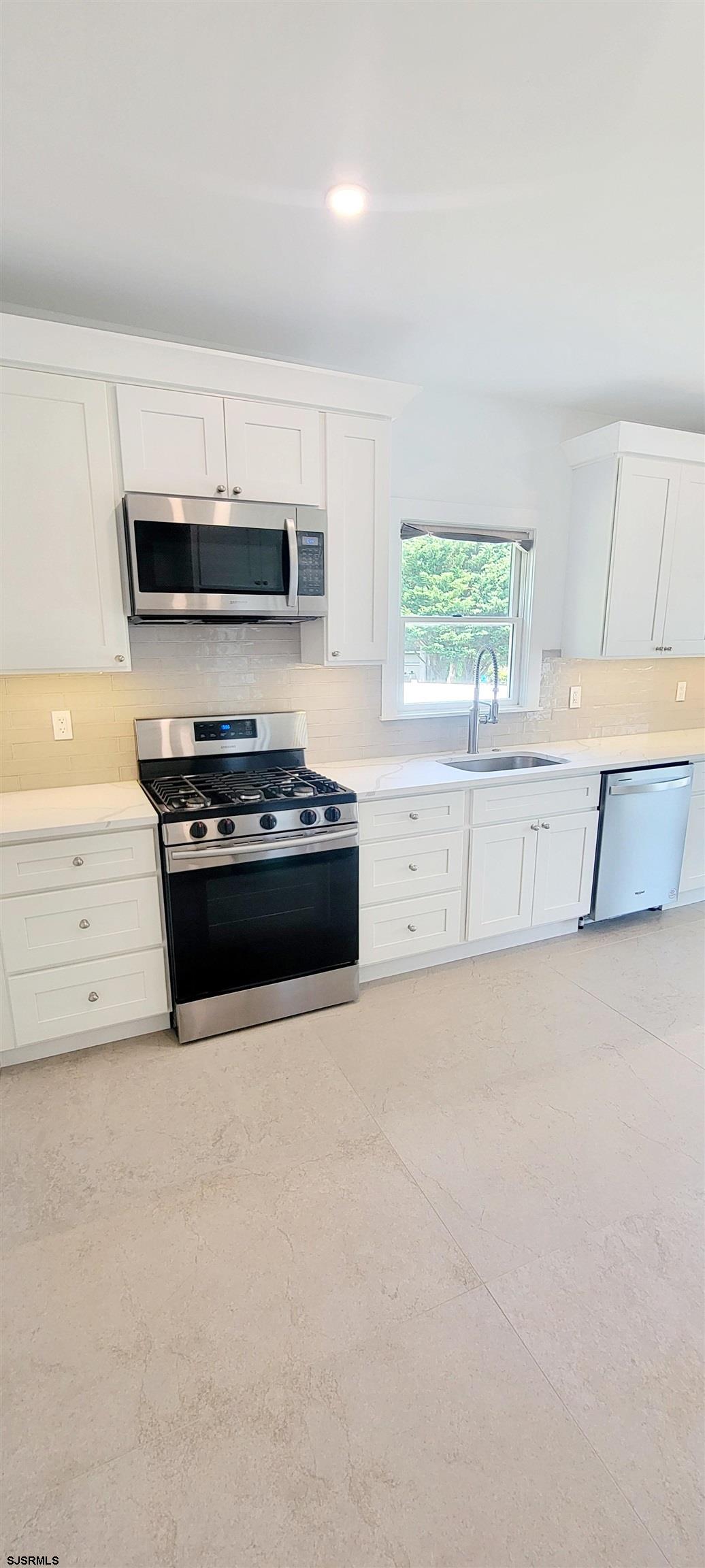 6594 Mill Road Egg Harbor Township, NJ 08234 - Photo 19 of 72 a kitchen with stainless steel appliances a stove a microwave and white cabinets