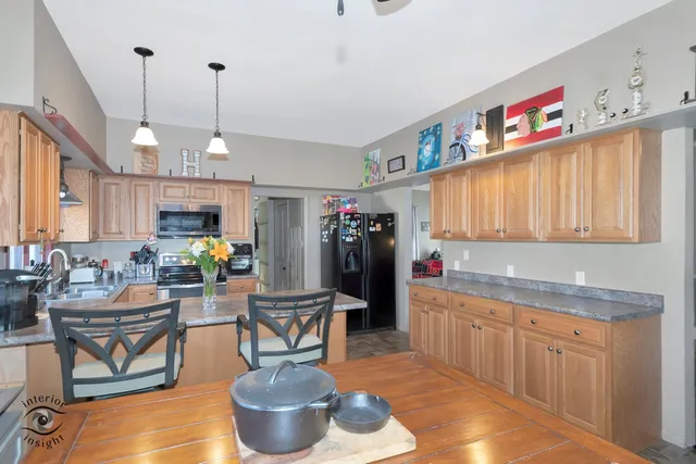 a kitchen with stainless steel appliances kitchen island granite countertop a sink cabinets and window