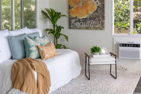 a bedroom with a bed and a potted plant