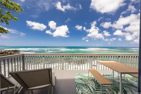 a view of a balcony with two chairs and a table