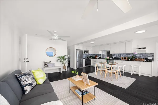 a living room with furniture kitchen view and a window