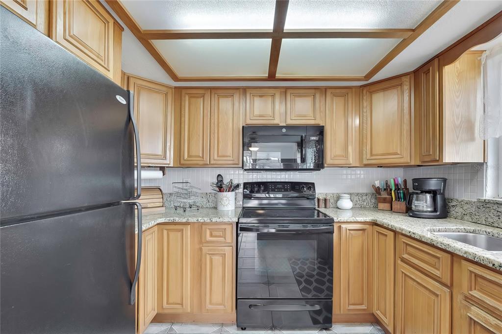 6601 Sea Ranch Drive Hudson, FL 34667 - Photo 12 of 43 a kitchen with stainless steel appliances granite countertop a sink stove and microwave