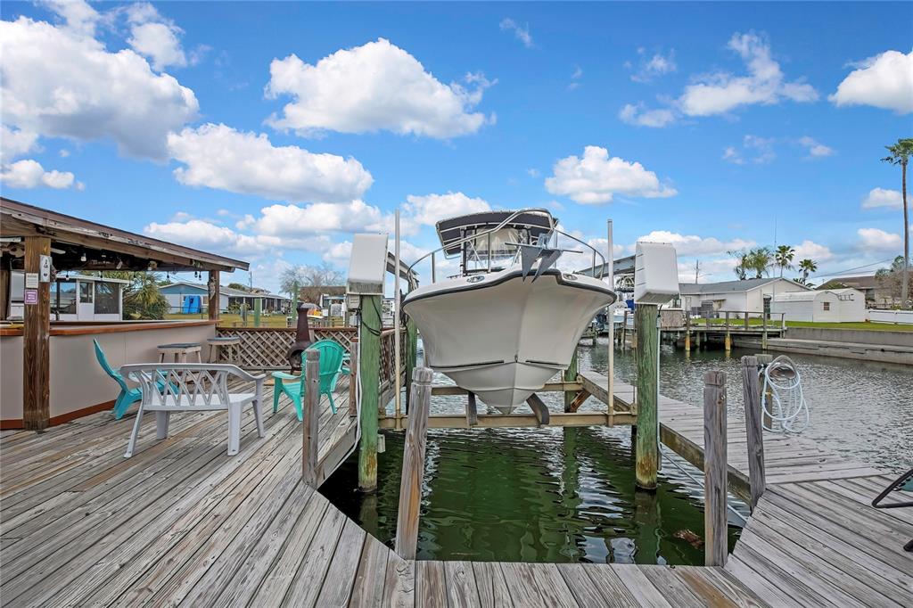 6601 Sea Ranch Drive Hudson, FL 34667 - Photo 28 of 43 a view of a roof deck with table and chairs a barbeque with wooden floor