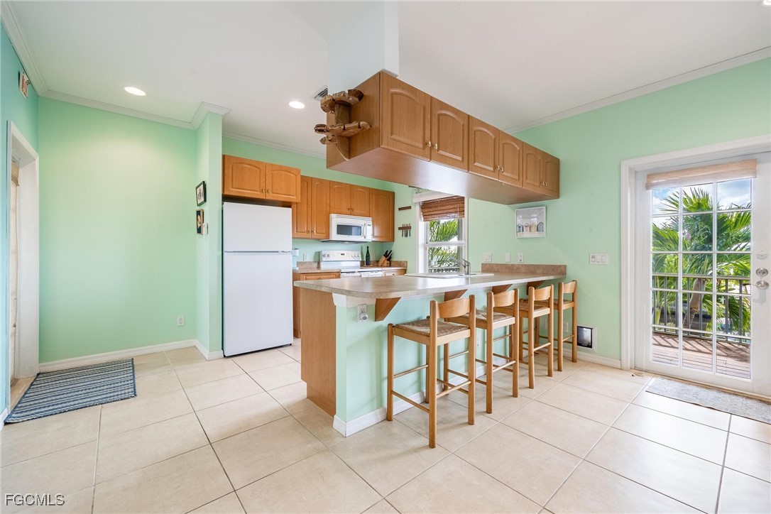 2761 Geary Street Matlacha, FL 33993 - Photo 7 of 50 a dining hall with stainless steel appliances kitchen island granite countertop a table and chairs in it