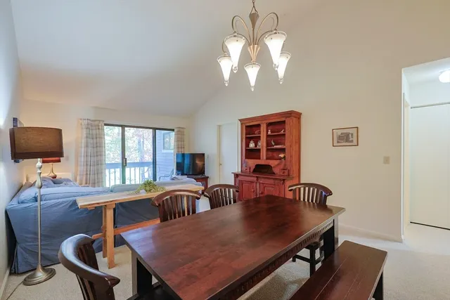 a view of a dining room with furniture a chandelier and wooden floor