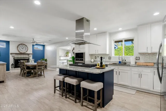 a kitchen with cabinets a sink and stove a refrigerator with wooden floor