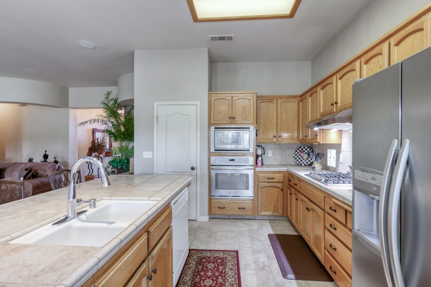 7360 Edgewater Street Chowchilla, CA 93610 - Photo 24 of 44 a kitchen with stainless steel appliances granite countertop a sink stove and refrigerator