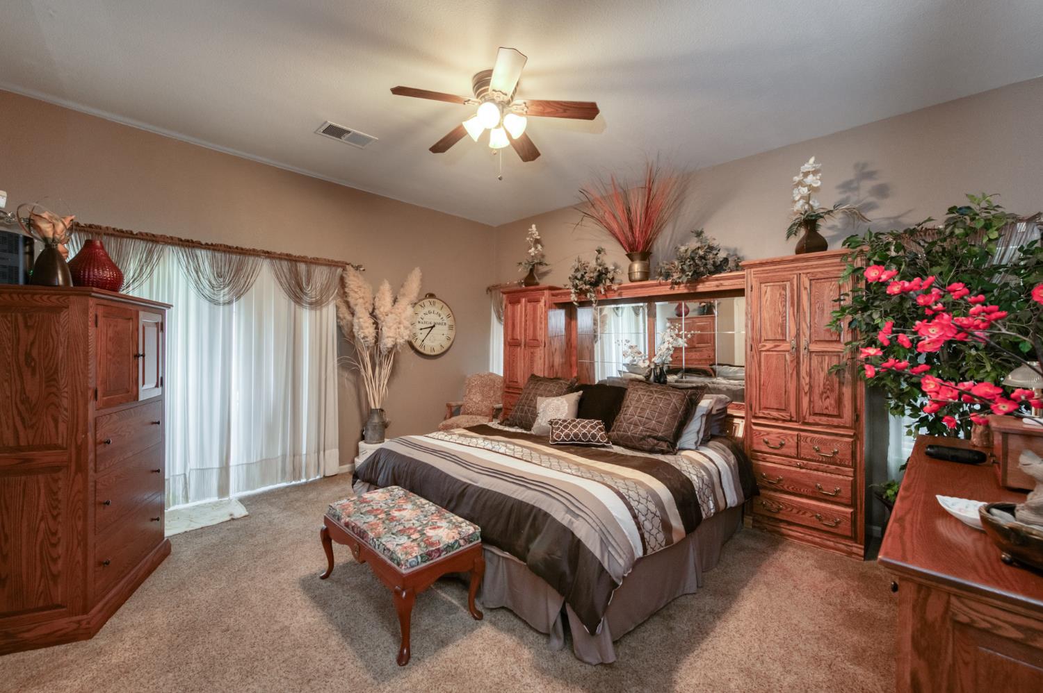 7360 Edgewater Street Chowchilla, CA 93610 - Photo 33 of 44 a bedroom with a bed mirror and a chandelier