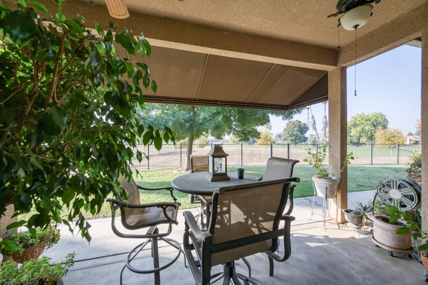7360 Edgewater Street Chowchilla, CA 93610 - Photo 39 of 44 a patio with table and chairs and potted plants