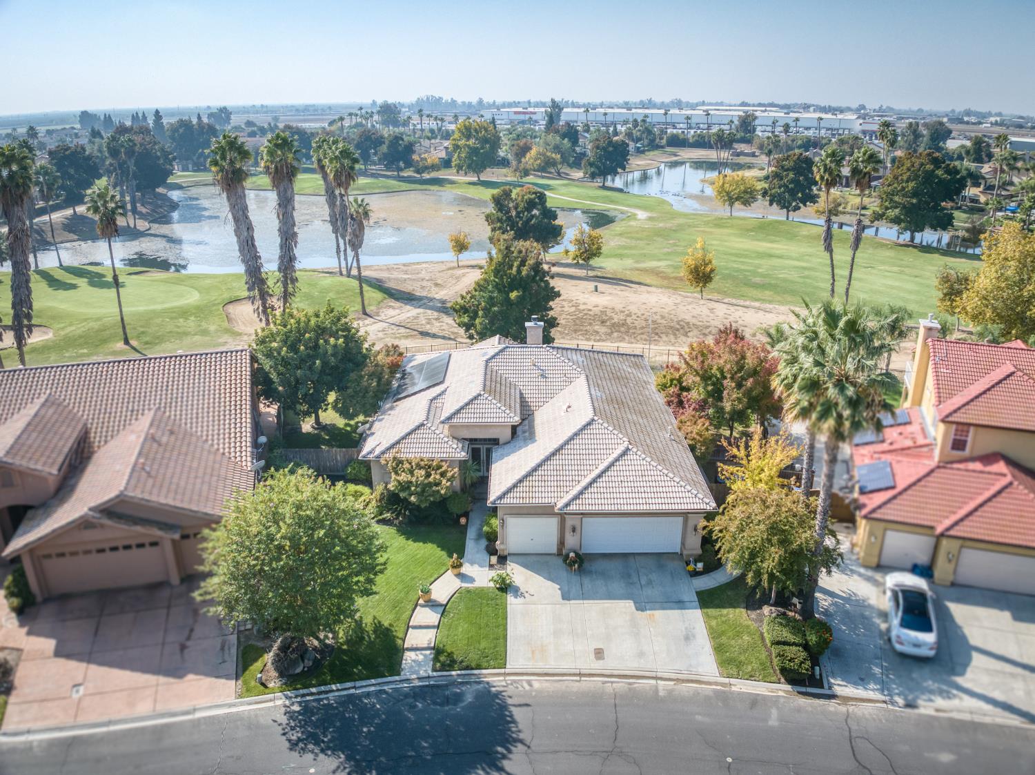 7360 Edgewater Street Chowchilla, CA 93610 - Photo 4 of 44 a view of a lake with a yard and potted plants