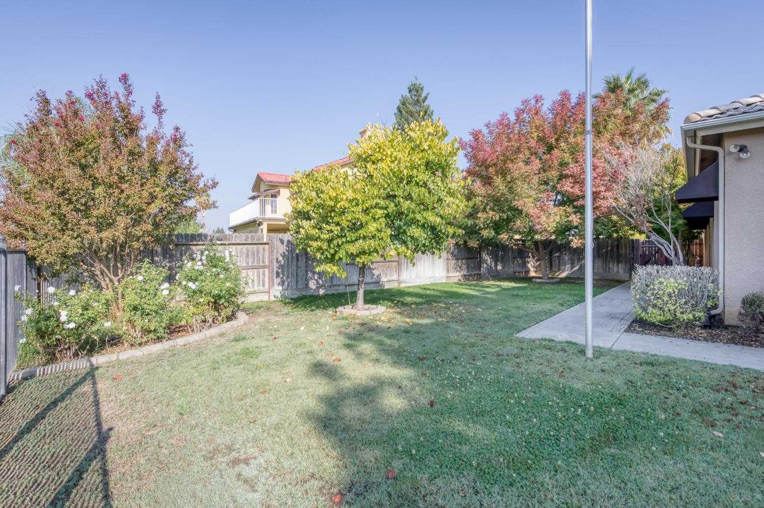 7360 Edgewater Street Chowchilla, CA 93610 - Photo 8 of 44 a view of a yard with plants and trees