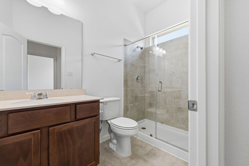 1005 Ridge Runner Drive Georgetown, TX 78628 - Photo 15 of 32 Bathroom featuring a dark wood-finish vanity with an integrated sink, polished chrome faucet, and a large wall-mounted mirror