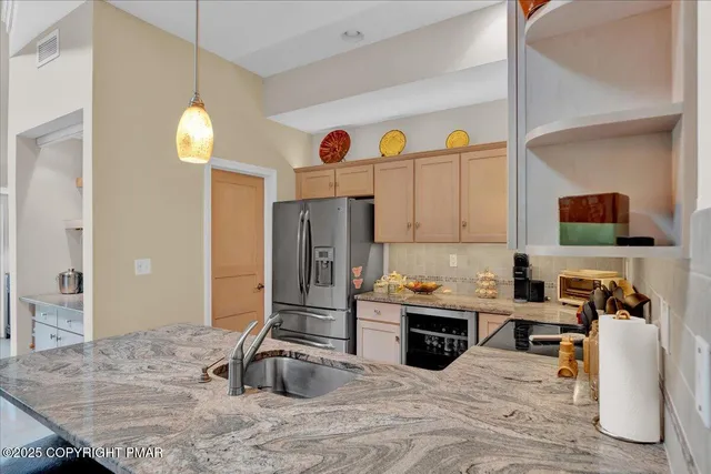 a kitchen with kitchen island granite countertop a sink counter top space and stainless steel appliances