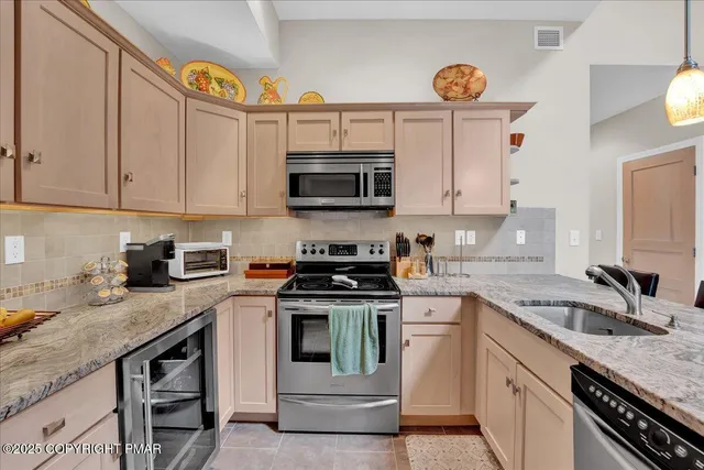 a kitchen with granite countertop a stove top oven sink and cabinets
