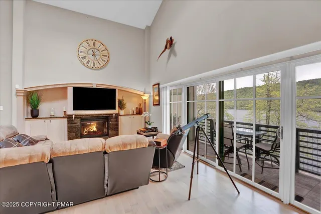a living room with furniture a flat screen tv and a floor to ceiling window