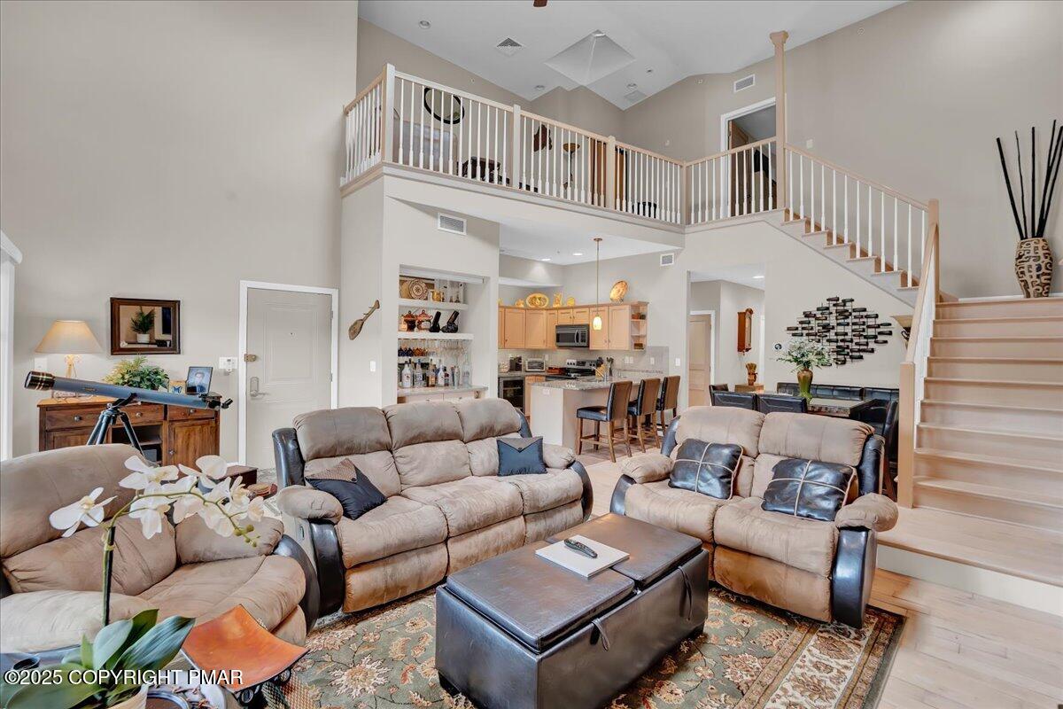 320 Hummingbird Way Lake, Unit 302J1 Lake Harmony, PA 18624 - Photo 7 of 29 a living room with furniture a rug and a chandelier