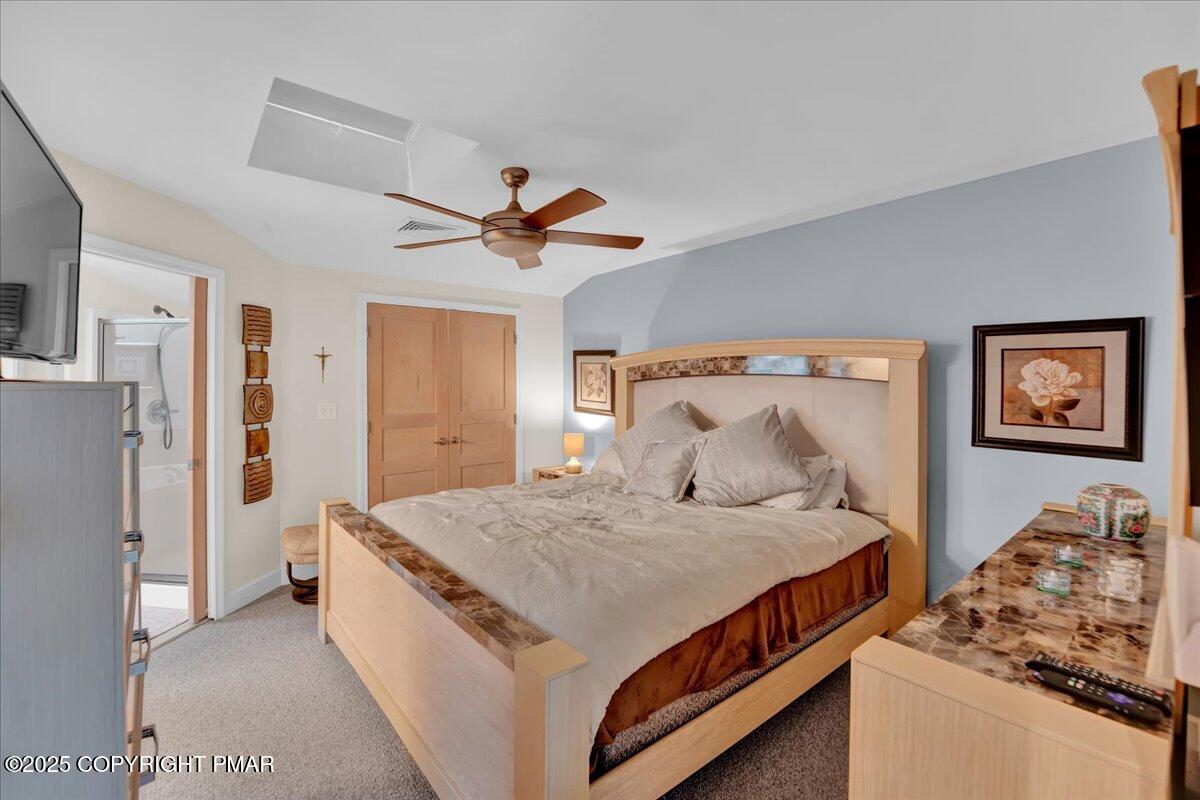 320 Hummingbird Way Lake, Unit 302J1 Lake Harmony, PA 18624 - Photo 9 of 29 a bedroom with a large bed and a chandelier