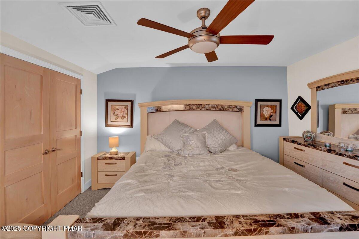 320 Hummingbird Way Lake, Unit 302J1 Lake Harmony, PA 18624 - Photo 10 of 29 a bedroom with a bed and a chandelier