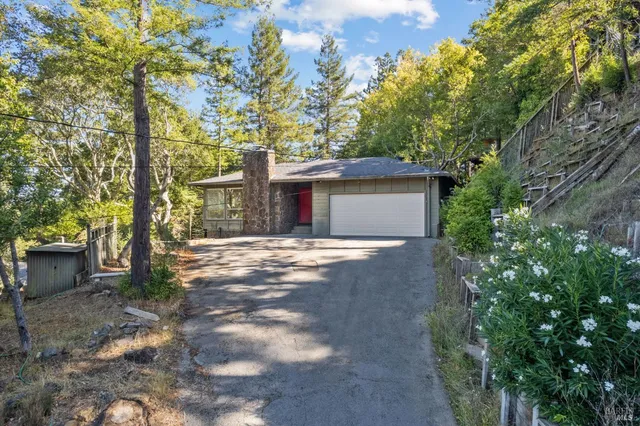 front view of a house with a yard and an trees