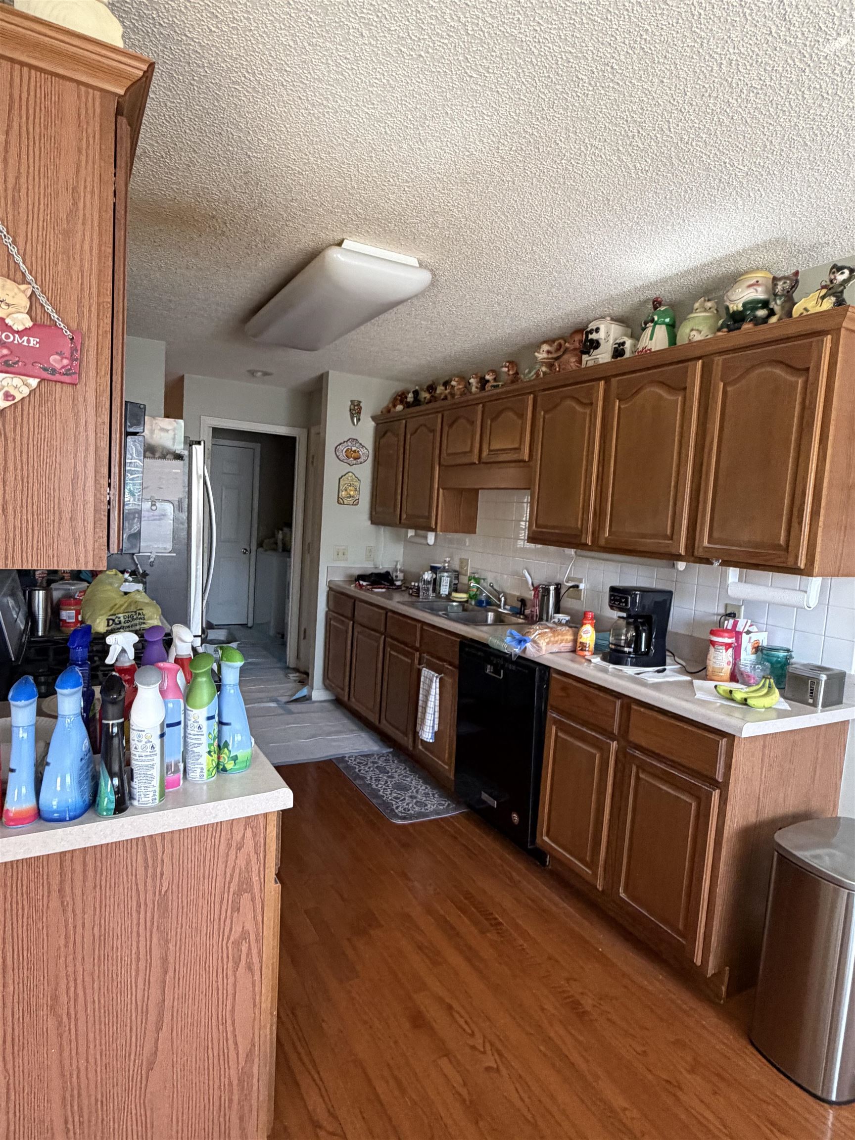 95 Lab Drive Buchanan, TN 38222 - Photo 18 of 19 Kitchen featuring dark wood-style floors, light countertops, black dishwasher, a textured ceiling, and decorative backsplash