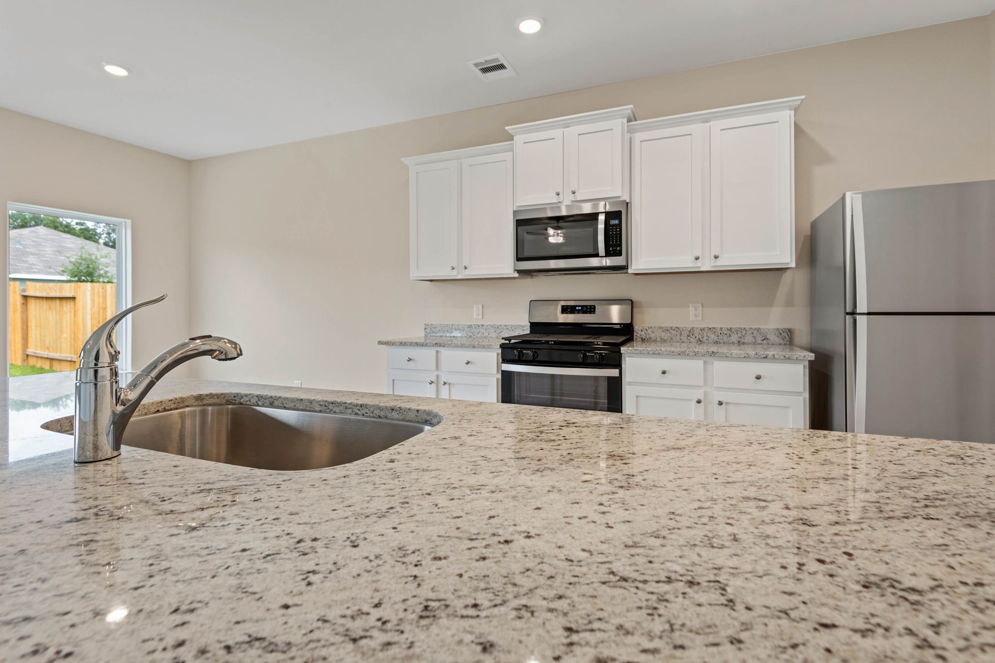10339 Red Cardinal Drive Cleveland, TX 77328 - Photo 8 of 23 a kitchen with stainless steel appliances a sink a stove a microwave a refrigerator a counter top space and cabinets