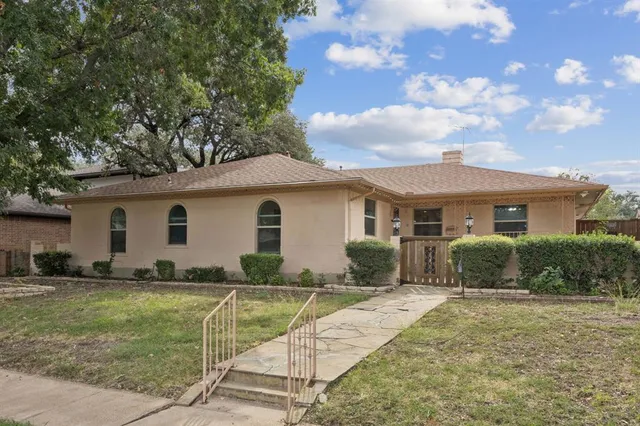 a front view of house with yard and trees around