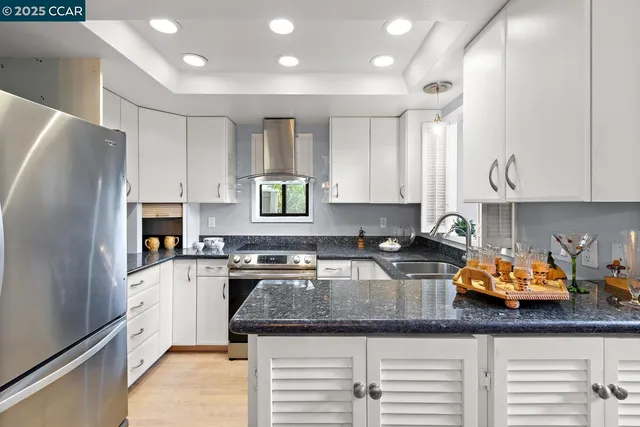 a kitchen with stainless steel appliances granite countertop a stove a sink and a microwave