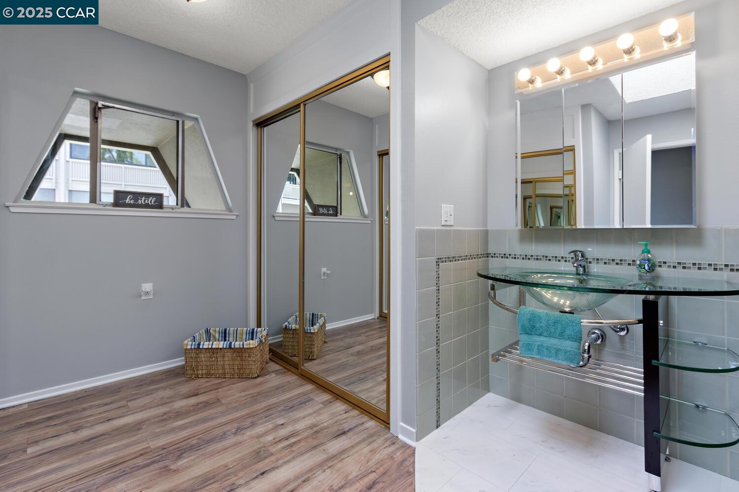1244 Singingwood Court, Unit 1 Walnut Creek, CA 94595 - Photo 26 of 46 a bathroom with a granite countertop sink and a mirror