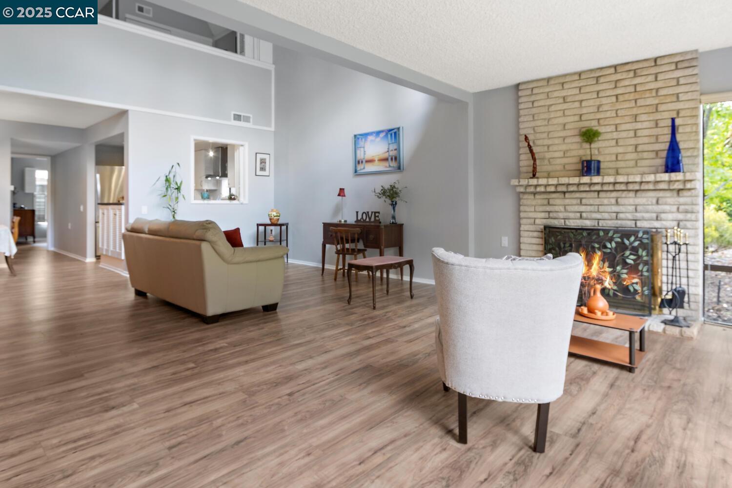1244 Singingwood Court, Unit 1 Walnut Creek, CA 94595 - Photo 5 of 46 a living room with fireplace furniture and a wooden floor