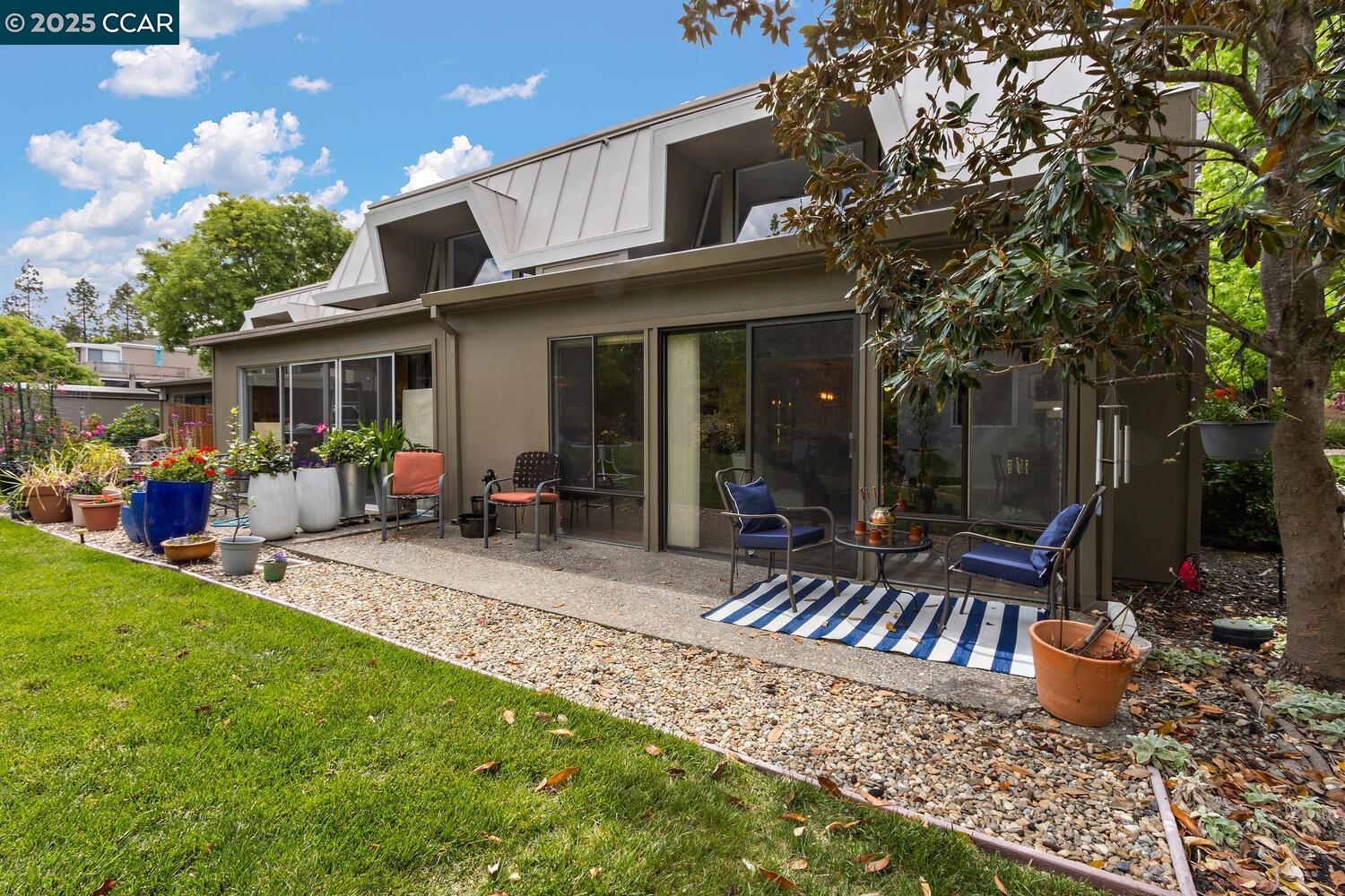 1244 Singingwood Court, Unit 1 Walnut Creek, CA 94595 - Photo 7 of 46 a view of a patio with table and chairs potted plants and large tree