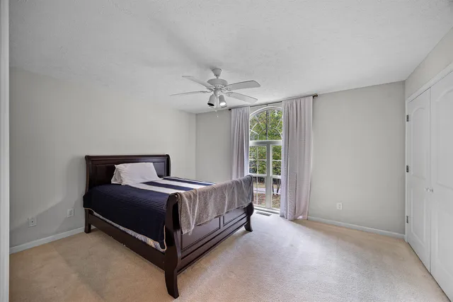 a bathroom with a sink a toilet a large mirror and shower curtain