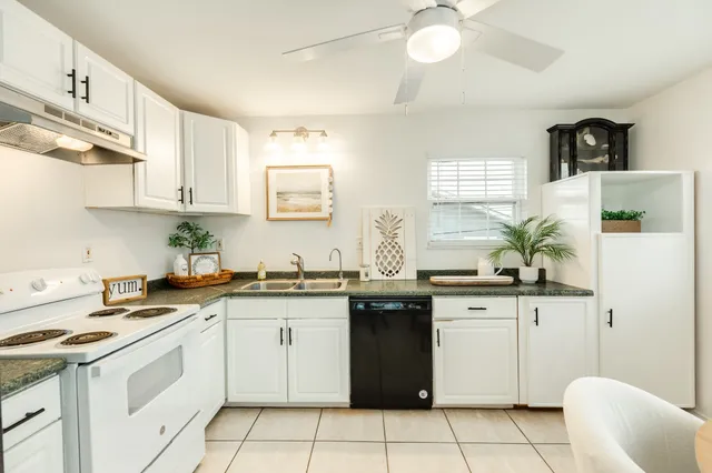 a kitchen with a sink a refrigerator and cabinets