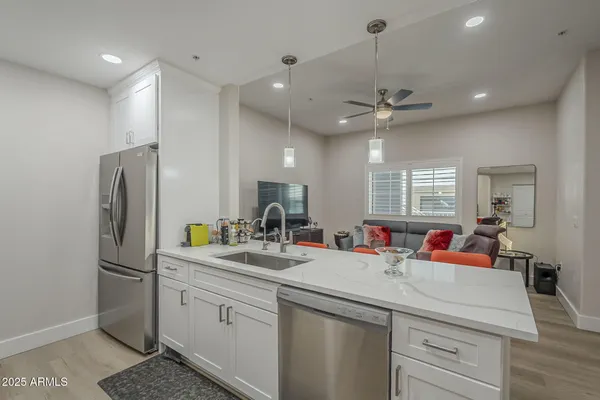 a kitchen with a sink stainless steel appliances and chandelier