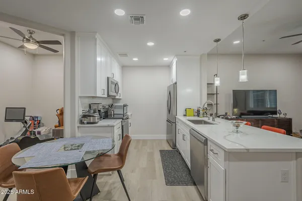 a kitchen with stainless steel appliances kitchen island granite countertop a sink and cabinets
