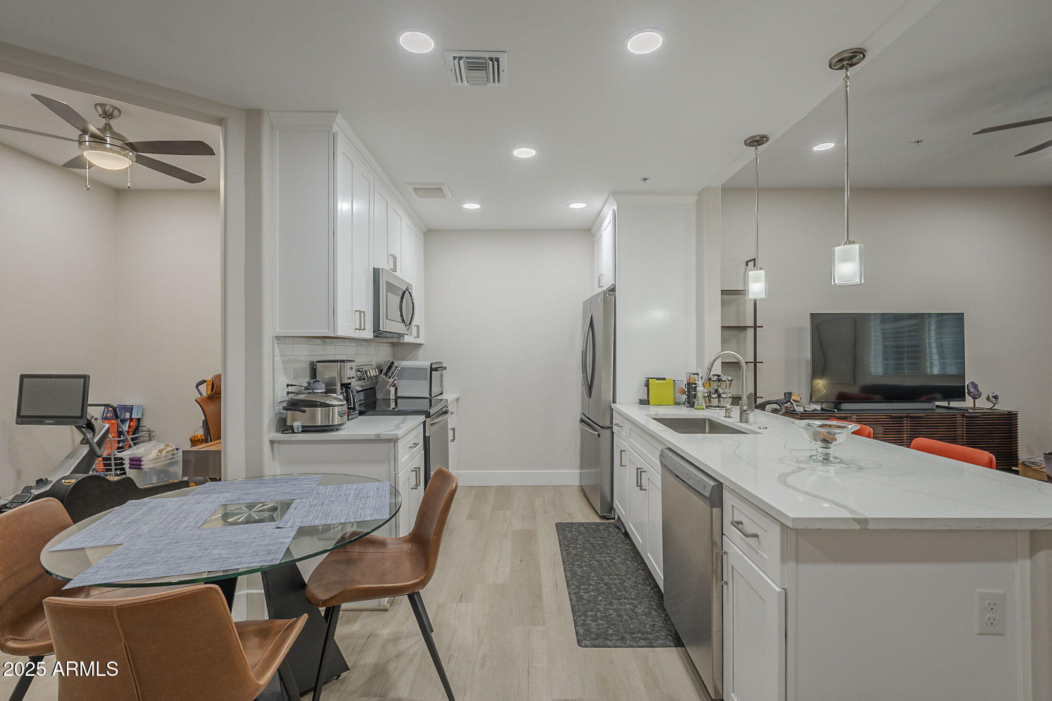 2038 East River Road, Unit 101 Tucson, AZ 85718 - Photo 3 of 21 a kitchen with a table chairs stove and cabinets