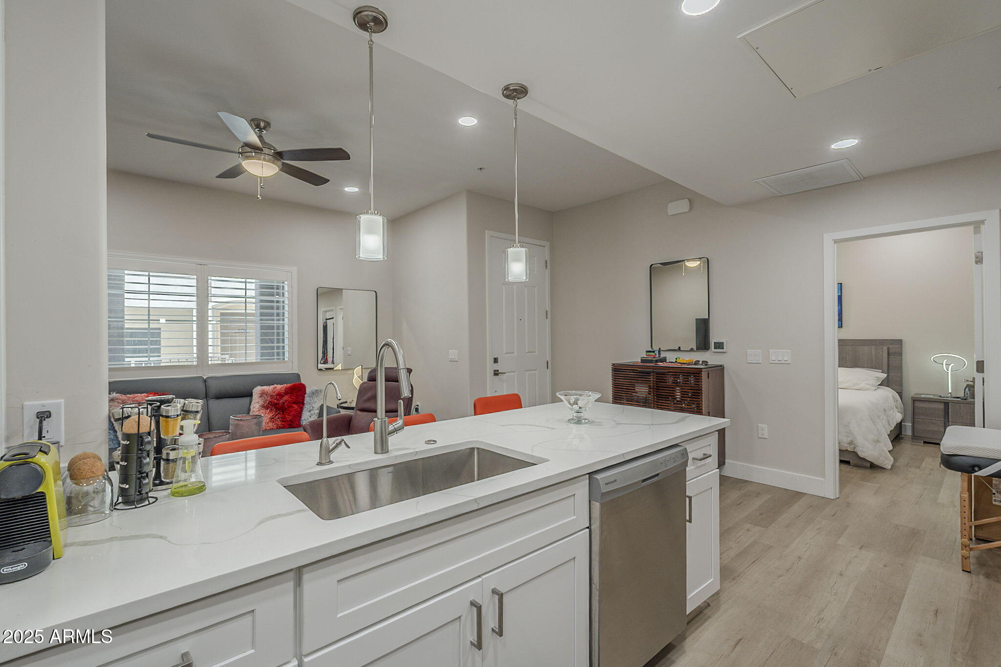 2038 East River Road, Unit 101 Tucson, AZ 85718 - Photo 4 of 21 a kitchen with a sink dishwasher a stove and white cabinets with wooden floor