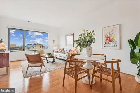 a dining room with furniture a large window and wooden floor