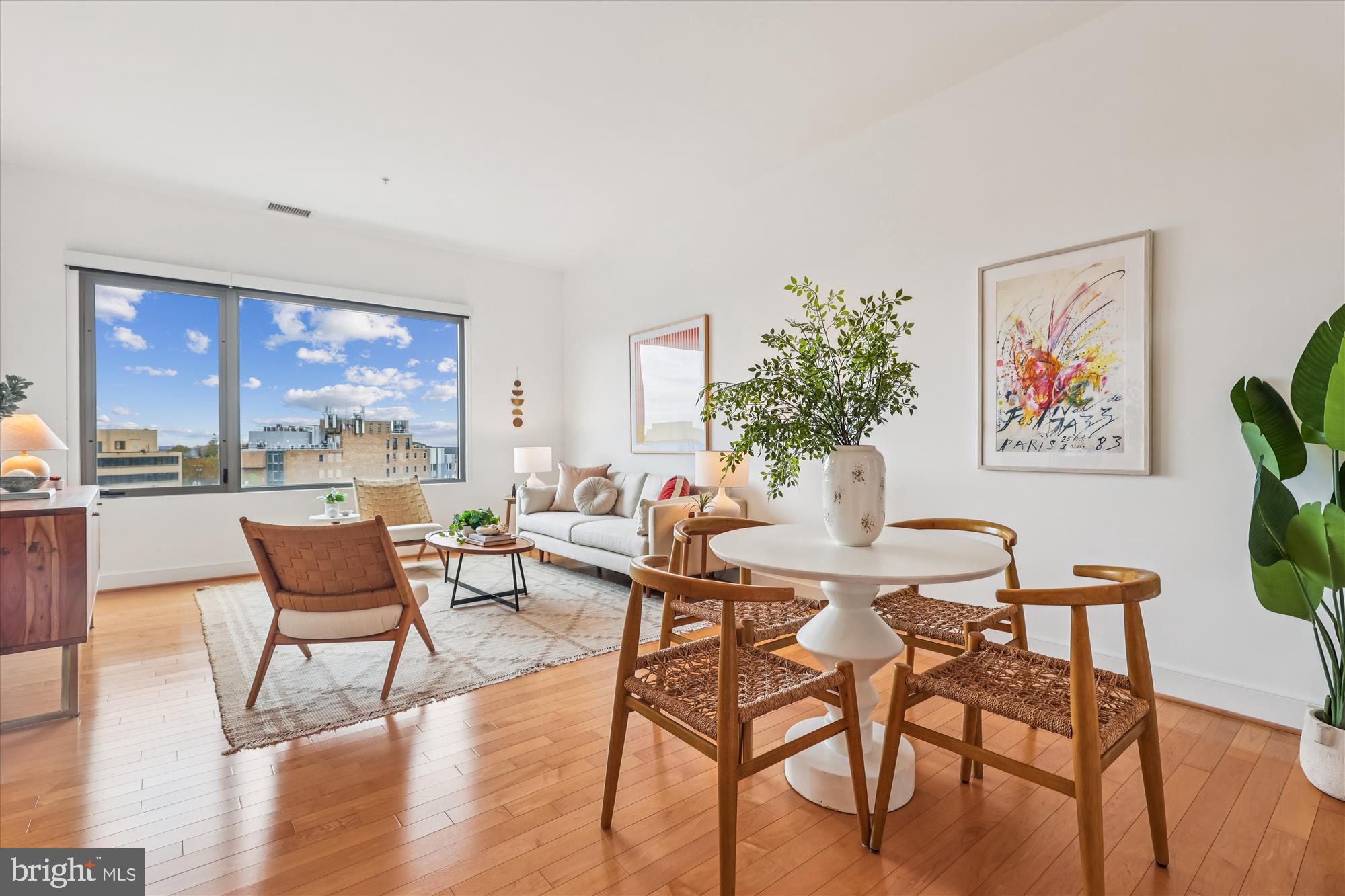 a dining room with furniture a large window and wooden floor