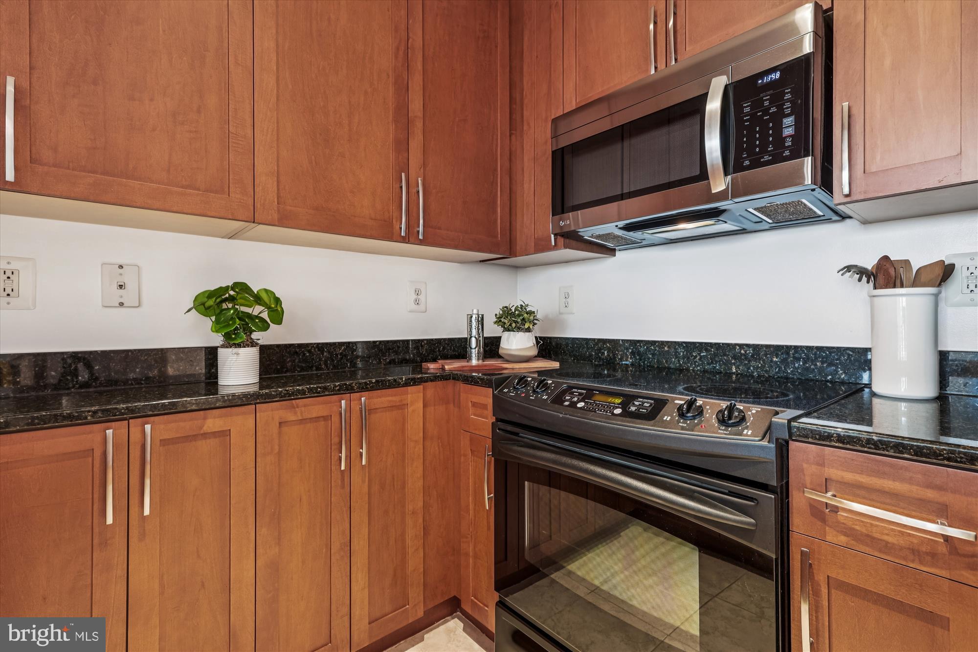 4101 Albemarle Street Northwest, Unit 623 Washington, DC 20016 - Photo 12 of 25 a kitchen with stainless steel appliances granite countertop a stove a microwave and cabinets