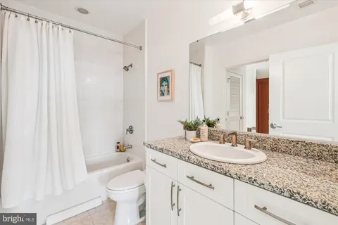 a bathroom with a granite countertop sink and a mirror a toilet
