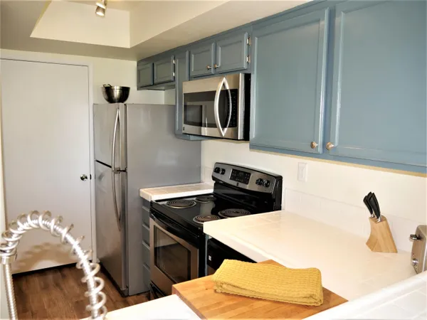 a kitchen with stainless steel appliances granite countertop a refrigerator and a stove top oven