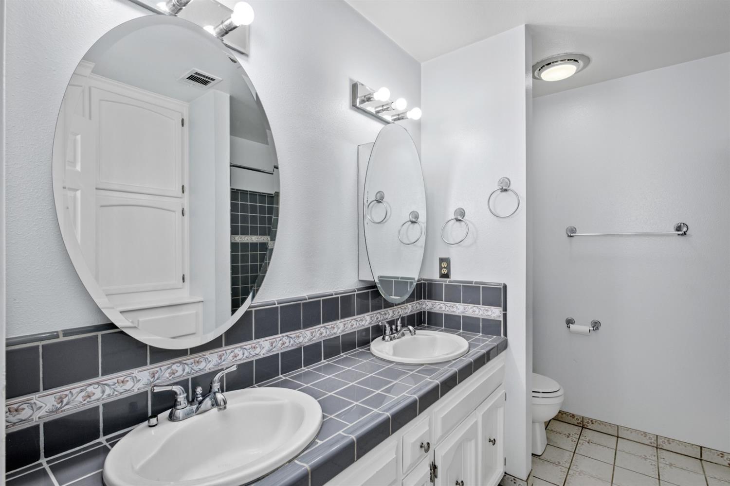 3140 North Temperance Avenue Clovis, CA 93611 - Photo 28 of 36 a bathroom with a granite countertop sink toilet a mirror and shower
