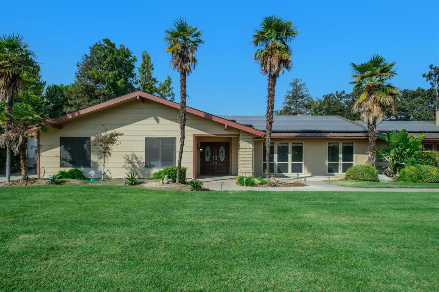 3140 North Temperance Avenue Clovis, CA 93611 - Photo 5 of 36 a front view of a house with a garden and trees