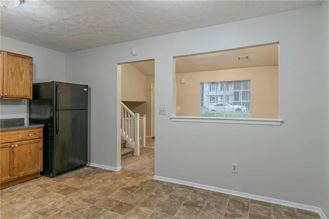 a view of a kitchen with refrigerator and wooden floor