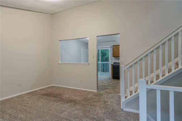 a view of a livingroom with wooden floor and stairs