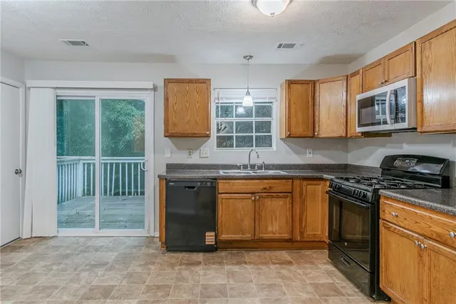 a kitchen with stainless steel appliances granite countertop a stove sink and microwave