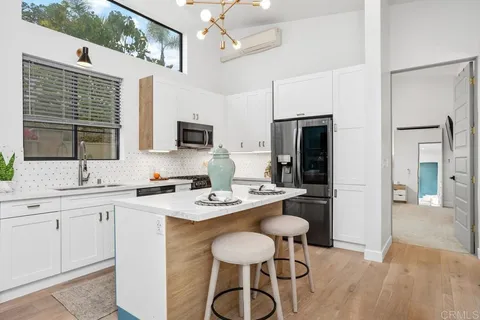 a kitchen with a refrigerator a stove a sink dishwasher with a dining table and chairs