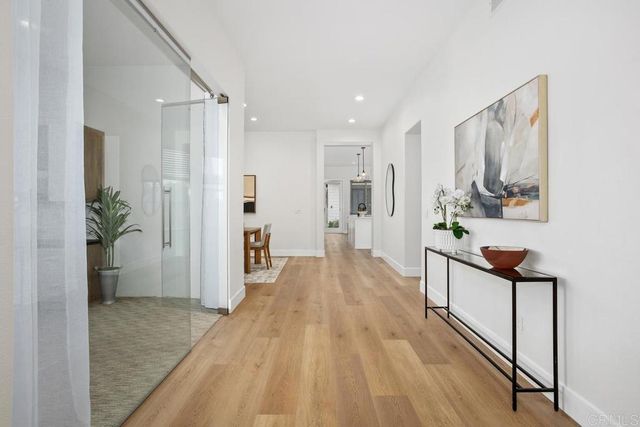 a view of a hallway with wooden floor and furniture