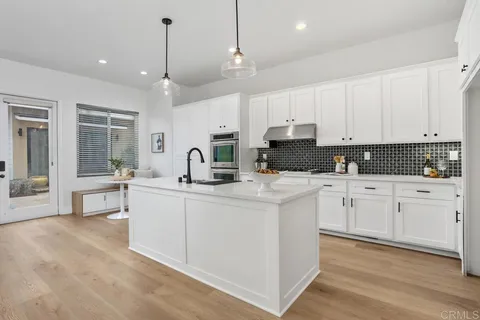 a kitchen with white cabinets and white appliances
